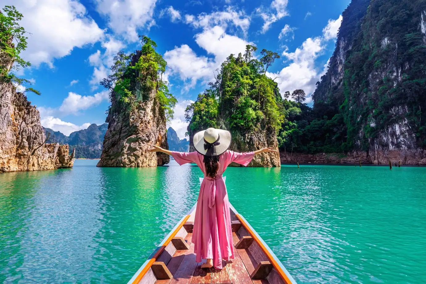 beautiful-girl-standing-boat-looking-mountains-ratchaprapha-dam-khao-sok-national-park-surat-thani-province-thailand_335224-849